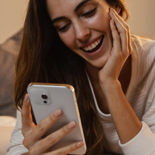 front-view-woman-using-smartphone-home
